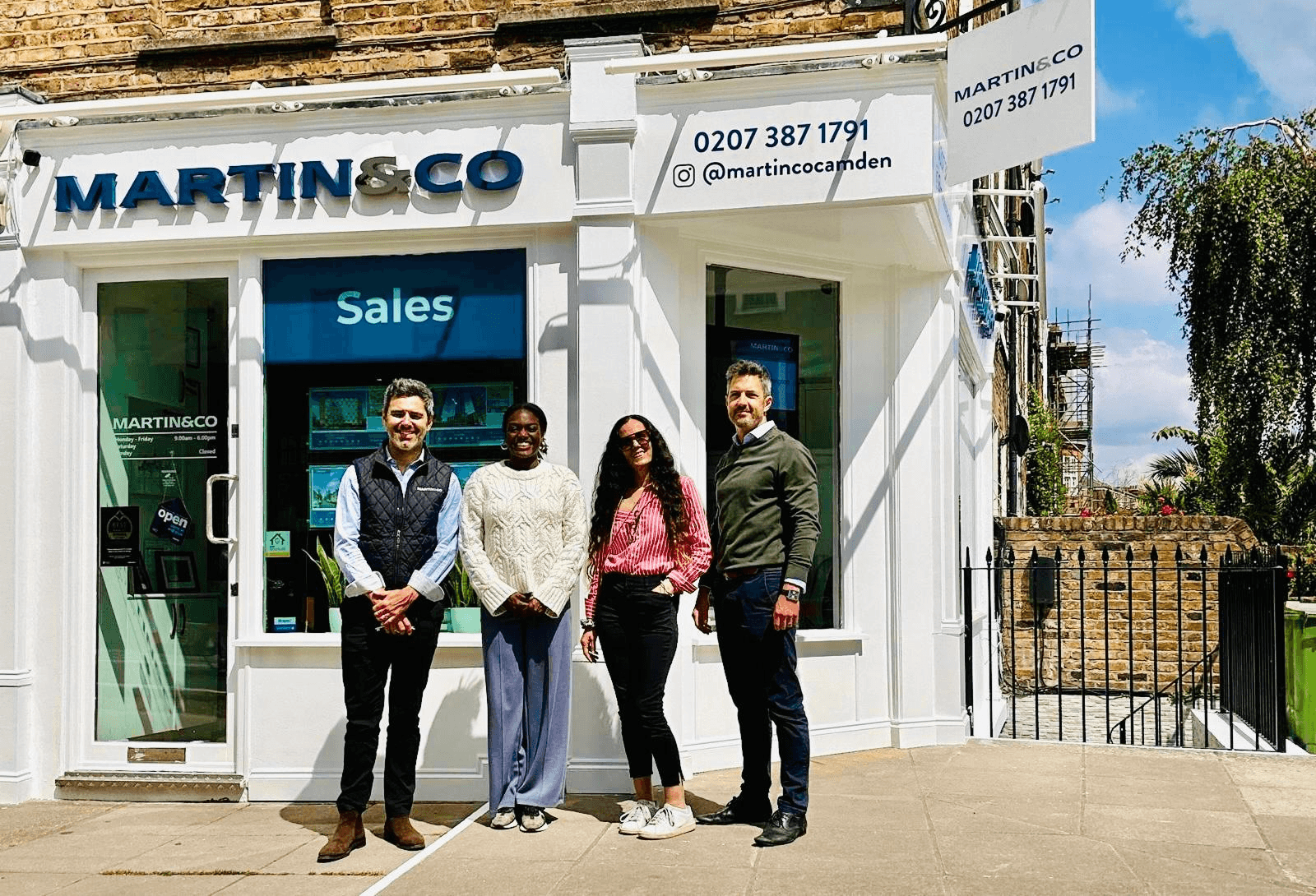 The Martin & Co Camden team of four standing outside their white-fronted branch on a sunny day